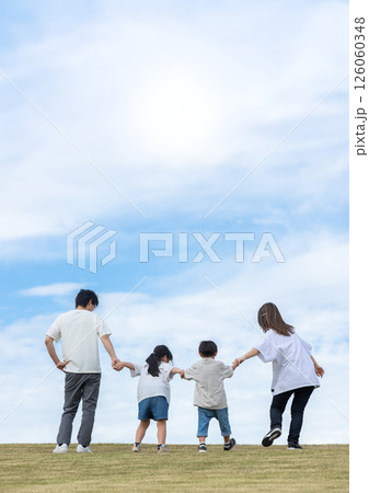 青空と丘の上に立つ家族 126060348