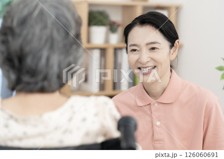 車椅子のシニア女性と話をする女性介護士 車椅子のシニア女性と話をする女性介護士 126060691