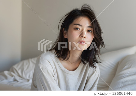 光の差し込む寝室でリラックスする若い日本人女性 126061440