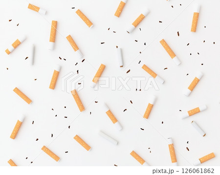 Many cigarettes and tobacco creating a chaotic pattern on white background 126061862