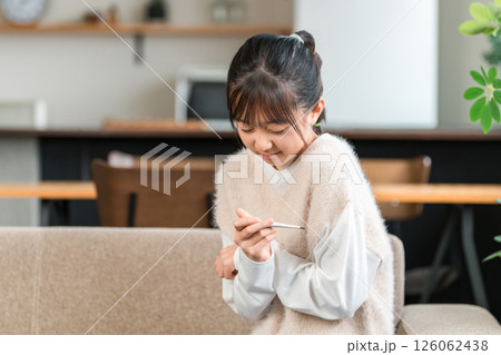 体調不良で体温計で検温する小学生,中学生の女の子 体調不良で体温計で検温する小学生,中学生の女の子 126062438