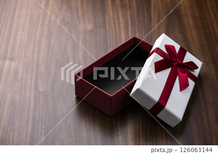 木のテーブルに開いた赤いリボンのギフトボックス 126063144