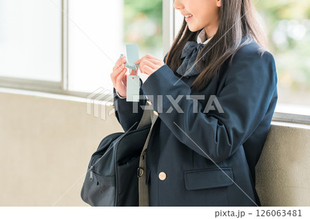 学校の廊下で単語帳を見ながら勉強するブレザー姿の女の子 126063481