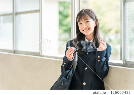 学校の廊下で単語帳を見ながら勉強するブレザー姿の女の子 126063482
