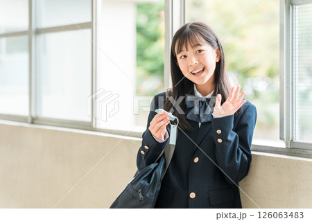 学校の廊下で単語帳を見ながら勉強するブレザー姿の女の子 126063483