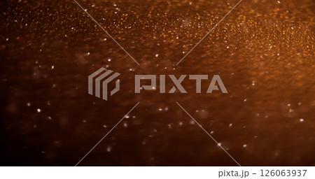 Bokeh light. Glowing trail. Defocused golden color sparkling glitter texture on shimmering dark abstract modern background. 126063937