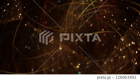 Garland blur. Golden sparks. Glittering yellow color stars lens flare swirling on dark bokeh light modern abstract background. 126063991