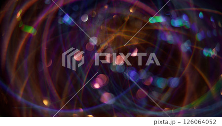 Kaleidoscope reflection. Defocused festive flickers. Purple color shining particles lens flare motion on blurred bokeh light background. 126064052