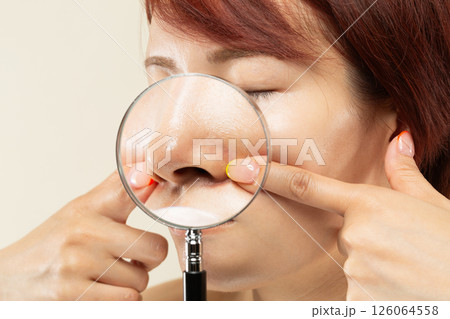 ルーペで女性の鼻を拡大している。 ルーペで女性の鼻を拡大している。 126064558