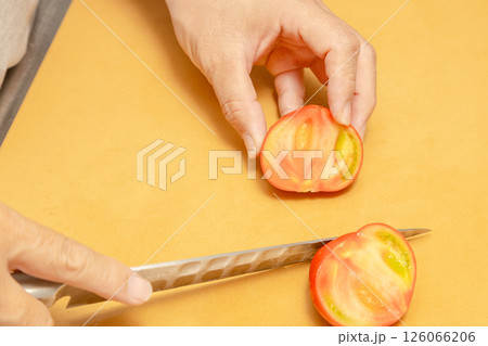トマトをカットしている手元の素材写真 126066206