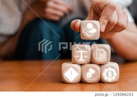 Wooden blocks with icons representing business contracts, legal agreements, and financial transactions in a professional setting. Wooden blocks with icons representing business contracts, legal agreements, and financial transactions in a professional setting. 126066281