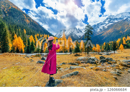 Tourist taking photo of Siguniangshan in autumn, Sichuan in China. 126066684