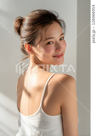 振り返る日本人女性の笑顔。柔らかな自然光に包まれたナチュラルポートレート 126066954