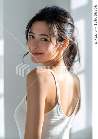 振り返る日本人女性の笑顔。柔らかな自然光に包まれたナチュラルポートレート 126066956