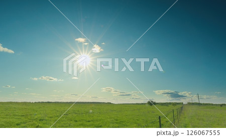 A Beautiful Bright and Sunny Day Over a Lush and Verdant Green Field Beneath a Clear Sky Time lapse. A Beautiful Bright and Sunny Day Over a Lush and Verdant Green Field Beneath a Clear Sky Time lapse. 126067555