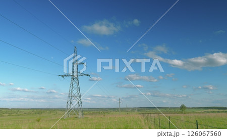 Towering, High Power Lines Stand Out Against a Beautiful Blue Sky with White Clouds Time lapse. 126067560