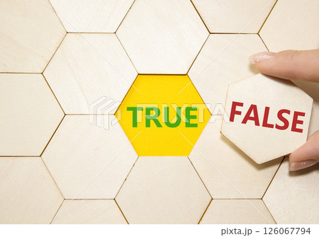 True or False symbol. Concept word True or False on wooden puzzle. Businessman hand. Beautiful yellow background. Business and True or False concept. Copy space 126067794