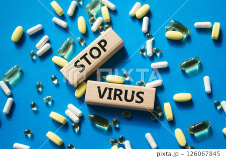 Stop Virus symbol. Concept word Stop Virus on wooden blocks. Beautiful blue background with pills. Medicine and Stop Virus concept. Copy space 126067845