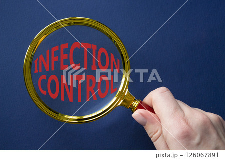 Infection Control symbol. Magnifying Glass with Concept word Infection Control. Businessman hand. Beautiful deep blue background. Business and Infection Control concept. Copy space 126067891