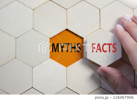 Facts or Myths symbol. Concept word Facts or Myths on wooden comb puzzle. Businessman hand. Beautiful orange background. Business and Facts or Myths concept. Copy space Facts or Myths symbol. Concept word Facts or Myths on wooden comb puzzle. Businessman hand. Beautiful orange background. Business and Facts or Myths concept. Copy space 126067906