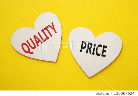 Price or Quality symbol. Concept word Price or Quality on wooden hearts. Beautiful yellow background. Business and Price or Quality concept. Copy space Price or Quality symbol. Concept word Price or Quality on wooden hearts. Beautiful yellow background. Business and Price or Quality concept. Copy space 126067924