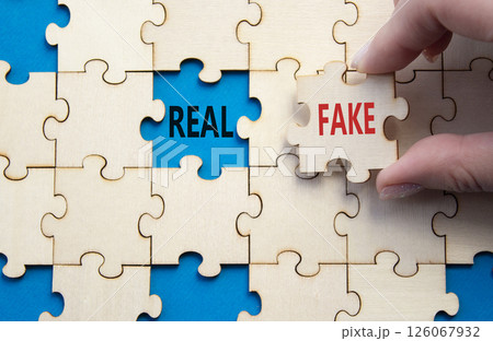 Real or Fake symbol. Concept word Real or Fake on wooden blocks. Businessman hand. Beautiful blue background. Business and Real or Fake concept. Copy space 126067932