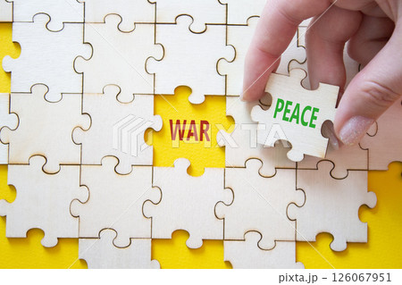 War or Peace symbol. Concept word War or Peace on wooden puzzle. Businessman hand. Beautiful yellow background. Business and War or Peace concept. Copy space 126067951