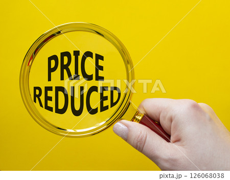 Price reduced symbol. Magnifying Glass with Concept word Price reduced. Beautiful yellow background. Businessman hand. Business and Price reduced concept. Copy space 126068038