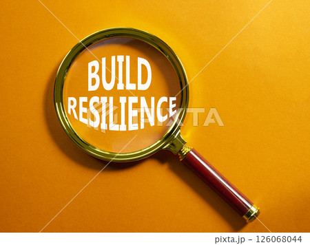 Build resilience symbol. Magnifying glass with words Build resilience. Beautiful orange background. Business and Build resilience concept. Copy space. 126068044
