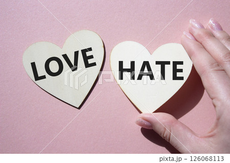 Love vs Hate symbol. Concept word Love vs Hate on wooden hearts. Businessman hand. Beautiful pink background. Business and Love vs Hate concept. Copy space 126068113