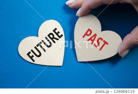 Future or Past symbol. Concept word Future or Past on wooden hearts. Businessman hand. Beautiful blue background. Business and Future or Past concept. Copy space 126068119