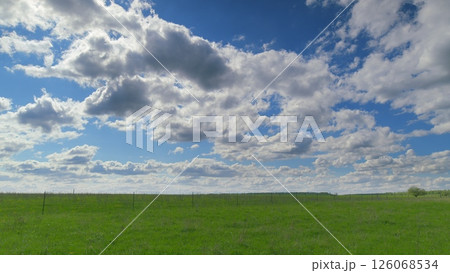 The Serene Green Fields Stretch Elegantly Underneath a Stunningly Beautiful Cloudy Sky Time lapse. 126068534