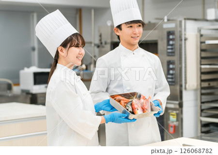魚を調理するコックコート姿の男女スタッフ(料理人・生鮮市場・食品加工) 魚を調理するコックコート姿の男女スタッフ(料理人・生鮮市場・食品加工) 126068782