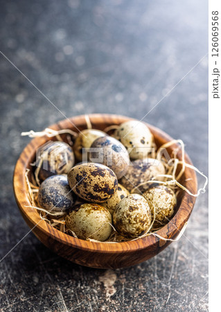 Spotted quail eggs in bowl on black table. Spotted quail eggs in bowl on black table. 126069568