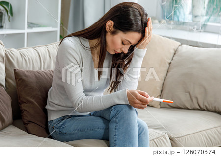 Disappointed woman after negative pregnancy result 126070374