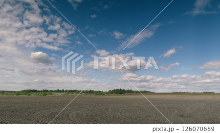 An Expansive Landscape Showcasing a Dramatic Cloudy Sky with a Vast, Dark Terrain Below 126070689