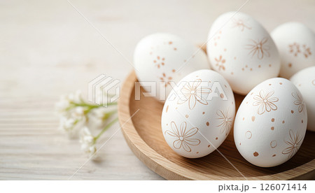 Hand painted Easter eggs in wooden bowl, adorned with floral designs and delicate patterns, evoke festive spirit 126071414
