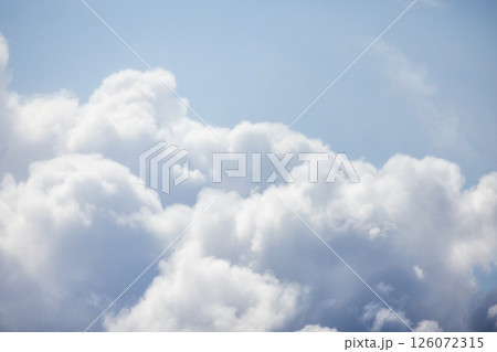 Soft, fluffy white clouds float in a serene bright blue sky Soft, fluffy white clouds float in a serene bright blue sky 126072315