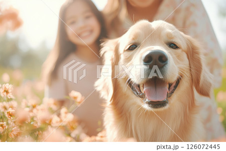 Cheerful golden retriever smiling in flower field with girl. warm sunlight creates joyful atmosphere, highlighting bond between dog and child 126072445