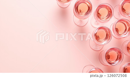 Elegant pink glasses filled with rose wine arranged on soft peach background create sophisticated and inviting atmosphere for celebrations 126072508