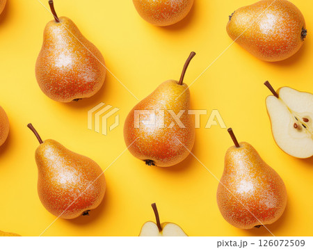 Shiny golden pears arranged on vibrant yellow background create playful and whimsical atmosphere. sparkling effect adds touch of magic to this delightful fruit display 126072509
