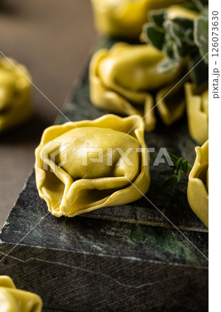 Fresh Tortellini with Herbs on Dark Green Background 126073630