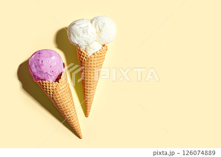 Two ice cream cones vanilla and blueberry flavors Two ice cream cones vanilla and blueberry flavors 126074889