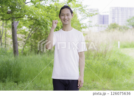 公園に立つガッツポーズをする若い男性のポートレート 126075636