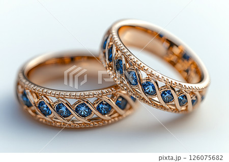 Luxurious pair of wedding rings with blue stones on a white background. Rococo-Renaissance style. Luxurious pair of wedding rings with blue stones on a white background. Rococo-Renaissance style. 126075682