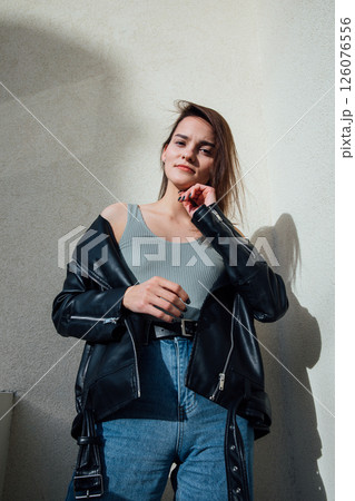 brunette woman posing in jeans and black leather jacket brunette woman posing in jeans and black leather jacket 126076556