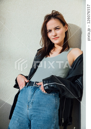 brunette woman posing in jeans and black leather jacket brunette woman posing in jeans and black leather jacket 126076557