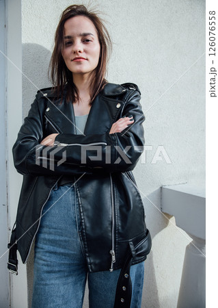 brunette woman posing in jeans and black leather jacket 126076558