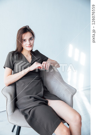 Portrait of Beautiful Fashion Woman in Green Dress on Chair 126076559
