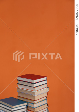 Stacks of educational books for learning on an orange background 126077290